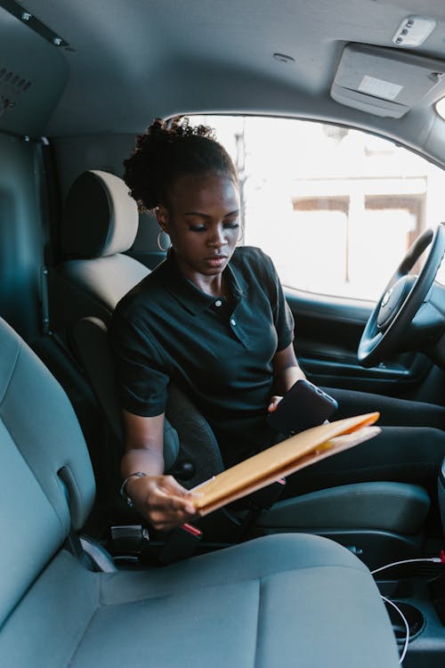 A Courier in Black Shirt Checking the Document Parcels