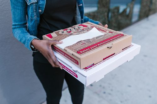 Free Woman holding pizza boxes for delivery in denim jacket outdoors. Stock Photo