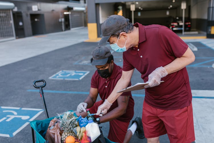 Men In Red Polo Shirts Checking Food In Cart