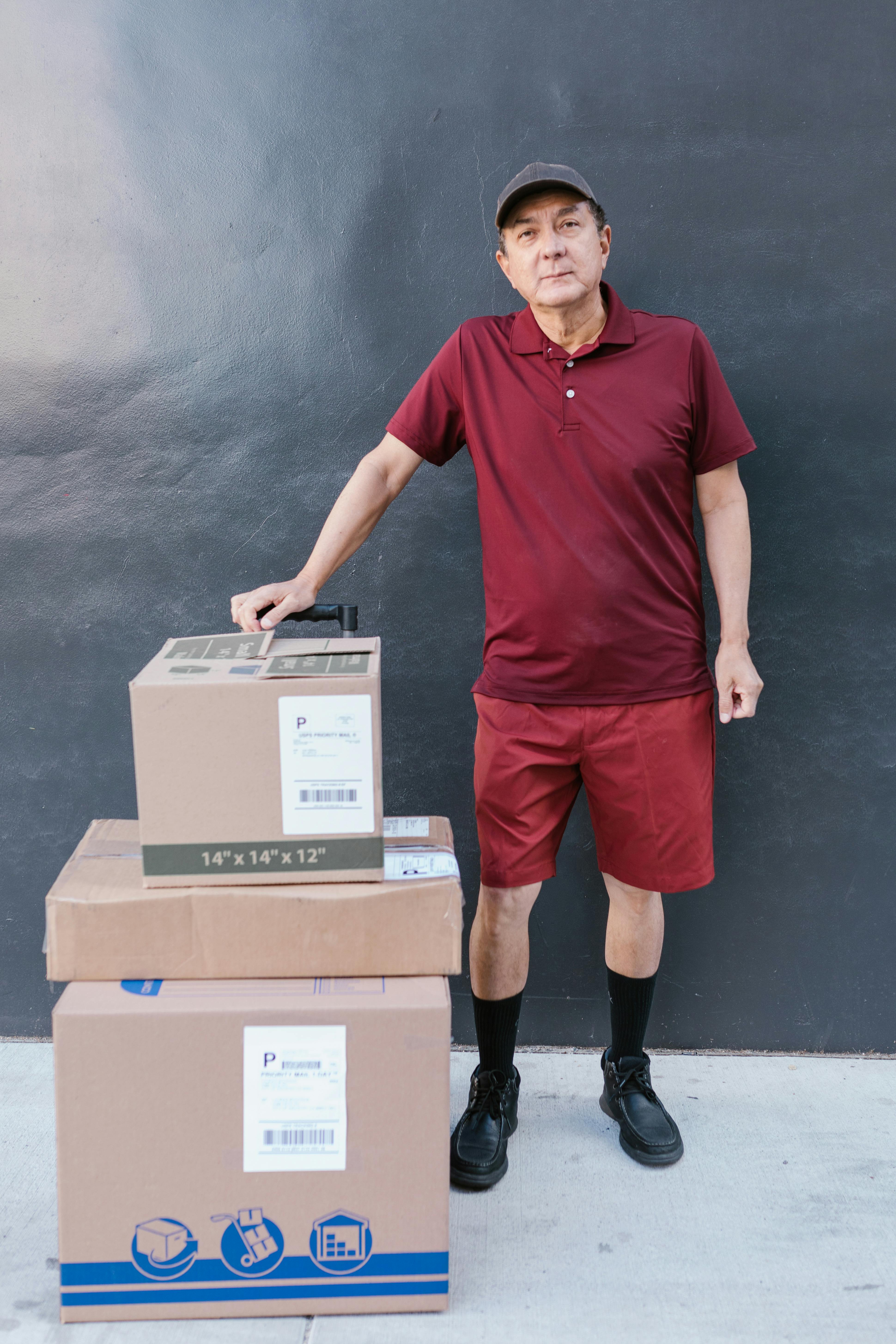 a elderly man in maroon shirt with packages for delivery