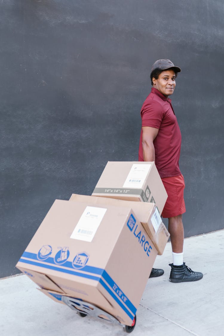 A Man In A Maroon Shirt Delivering Packages