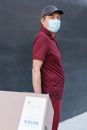Man in Red T-shirt Standing Near Black Wall