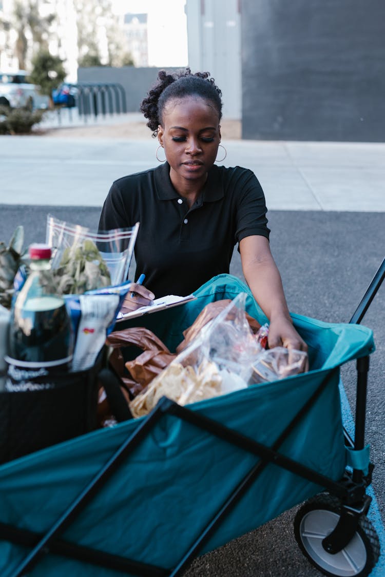 A Deliverywoman Inspecting Her Grocery Deliveries