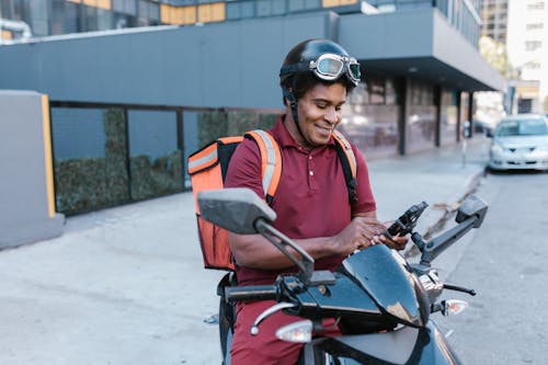 Woman in Orange Vest Riding on Red Motorcycle