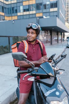 African American deliveryman on scooter with helmet and backpack in city.