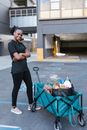Man in Black Long Sleeve Shirt and Black Pants Holding Red Shopping Cart
