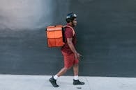 Man in Maroon Polo Shirt Walking Wearing Food Delivery Bag