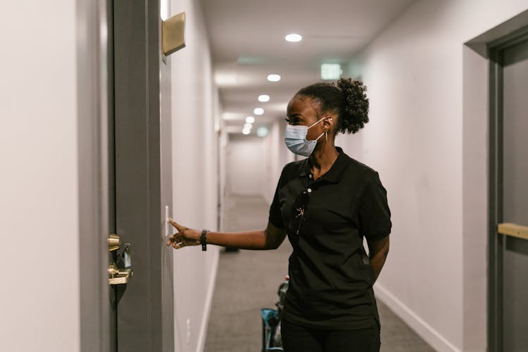 A Deliverywoman Pressing The Doorbell