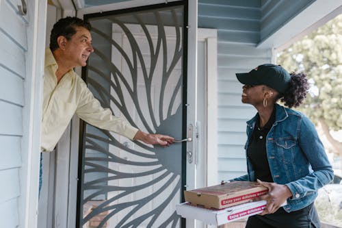 Free A Woman Delivering Boxes of Pizza Stock Photo