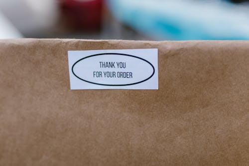 Close-Up Photo of a Sticker on a White Paper Bag