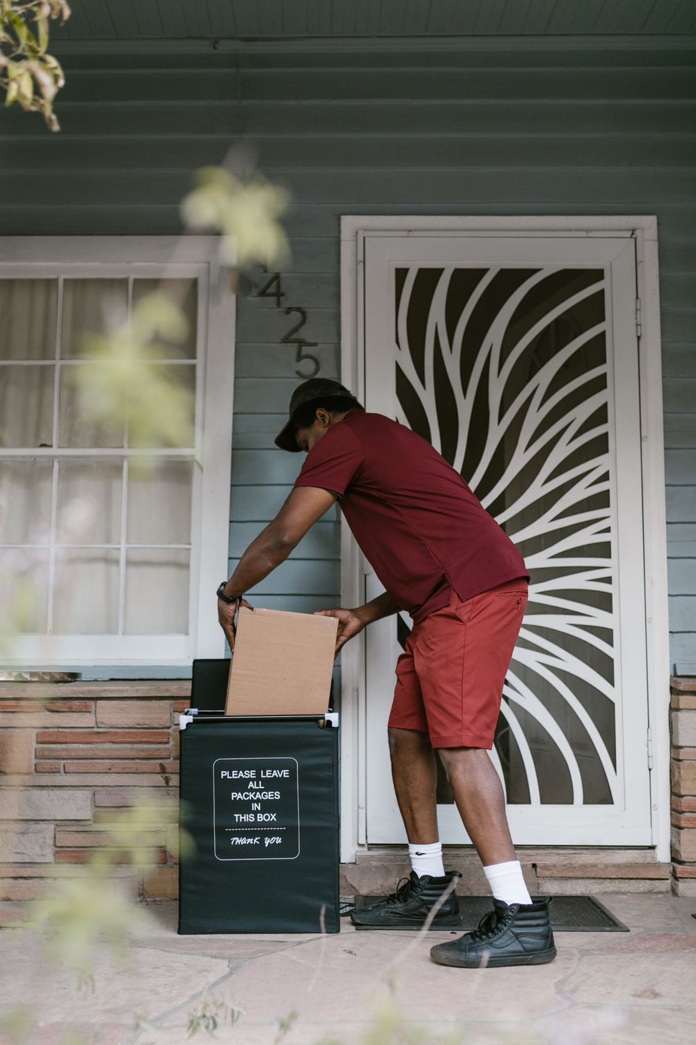 Courier placing a delivered package at a front door