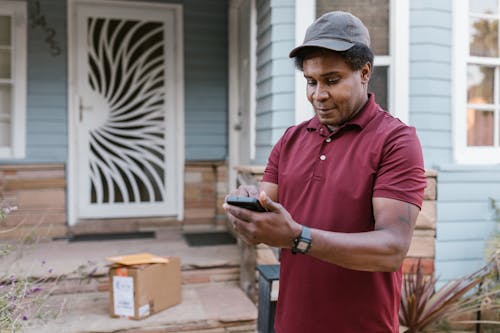 A Deliveryman Checking His Cellphone