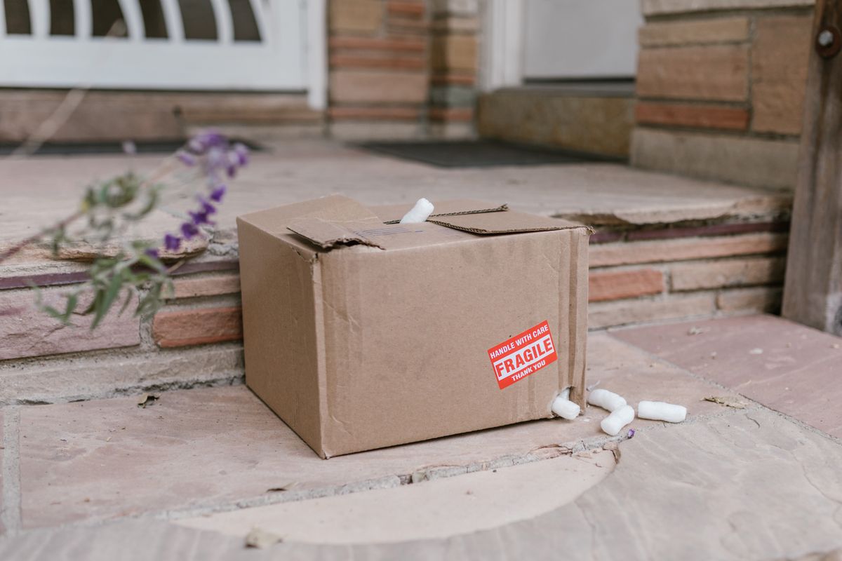 A severely damaged cardboard shipping box