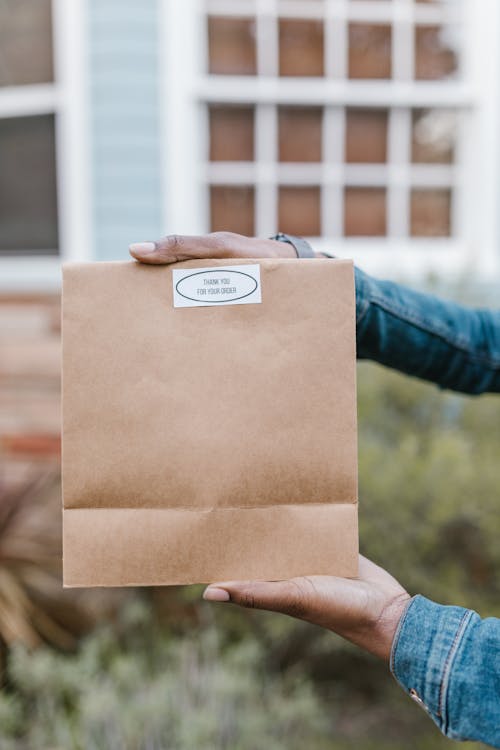 Person Holding Brown Paper Bag