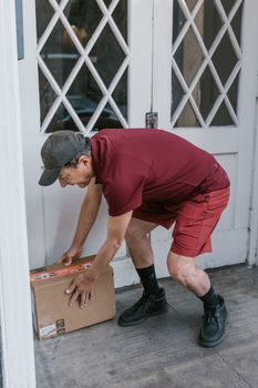 Courier delivering package at front door, showing logistics in action.