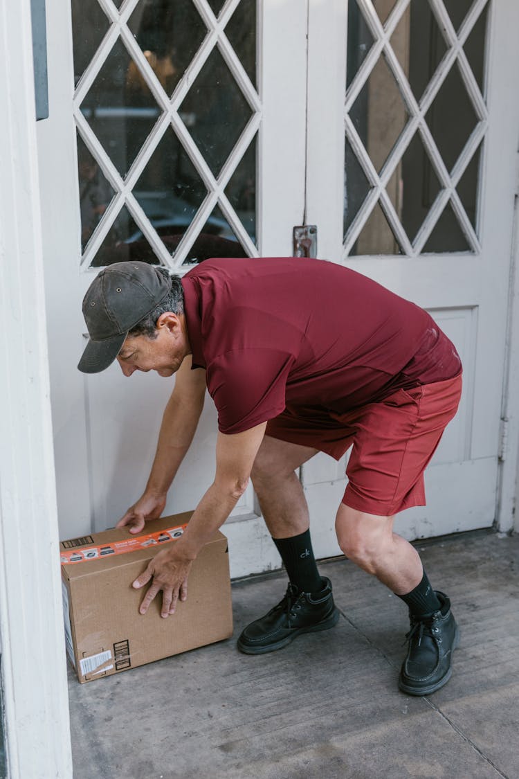 An Elderly Man Leaving A Package On The Front Door