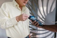 Adult Man in Yellow Long Sleeves Paying Using a Card