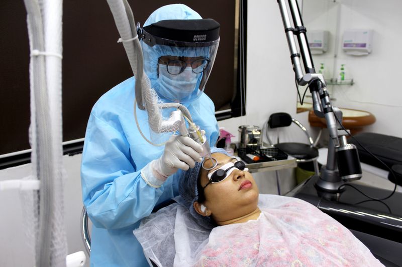 Clinician in full protective gear operating a resurfacing laser
