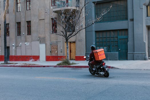 Street view of a courier on a motorcycle delivering in an urban setting.
