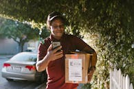 A Man in Red Polo Shirt Holding a Box