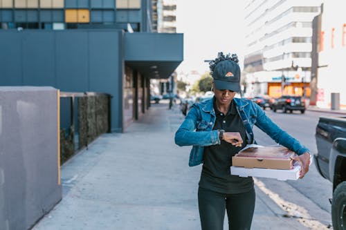 Free A Woman in Blue Denim Jacket Holding Pizza Boxes Stock Photo