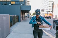 A Woman in Blue Denim Jacket Holding Pizza Boxes
