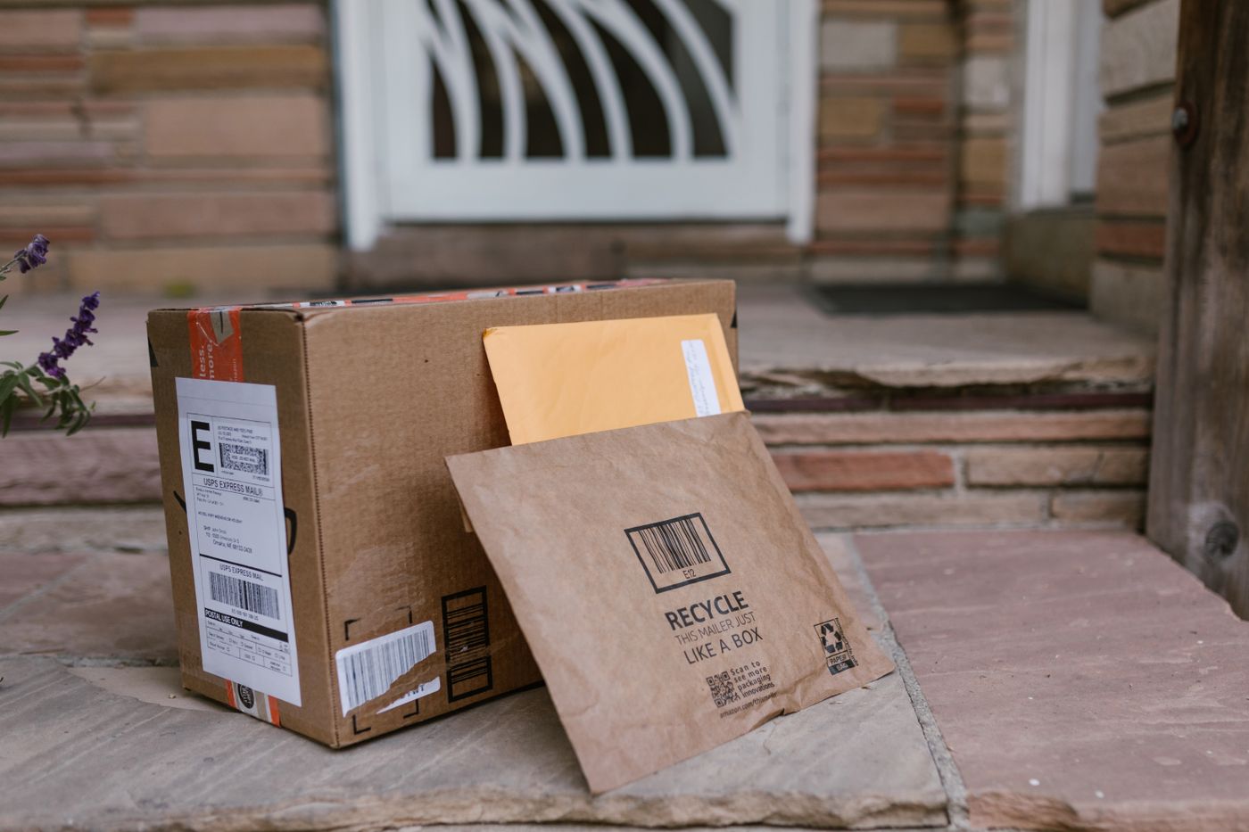 Delivered shipping packages placed beside a residential doorway