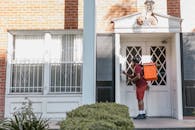 A Deliveryman Pressing the Doorbell