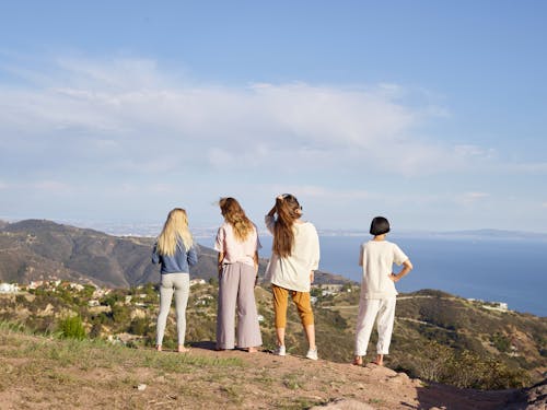 Women Standing on a Hill and Looking at the Sea and Mountains 
