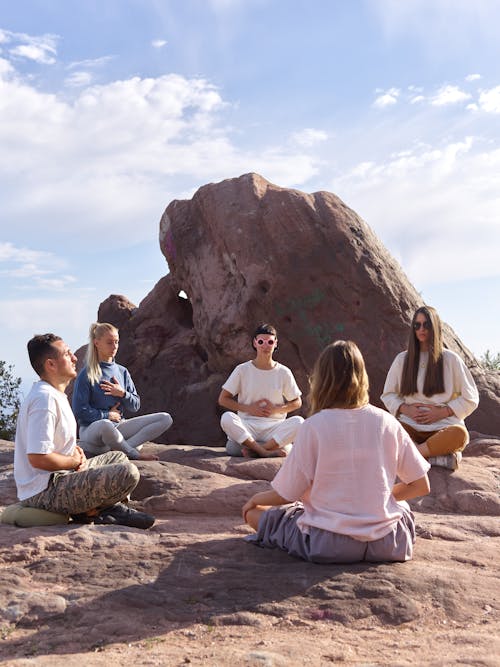 Group of People Sitting Crossed Legged in a Circle and Meditating 