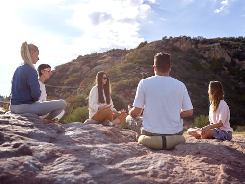 Free Group of People Sitting in Circle Crossed Legged with Mountain in the Background  Stock Photo