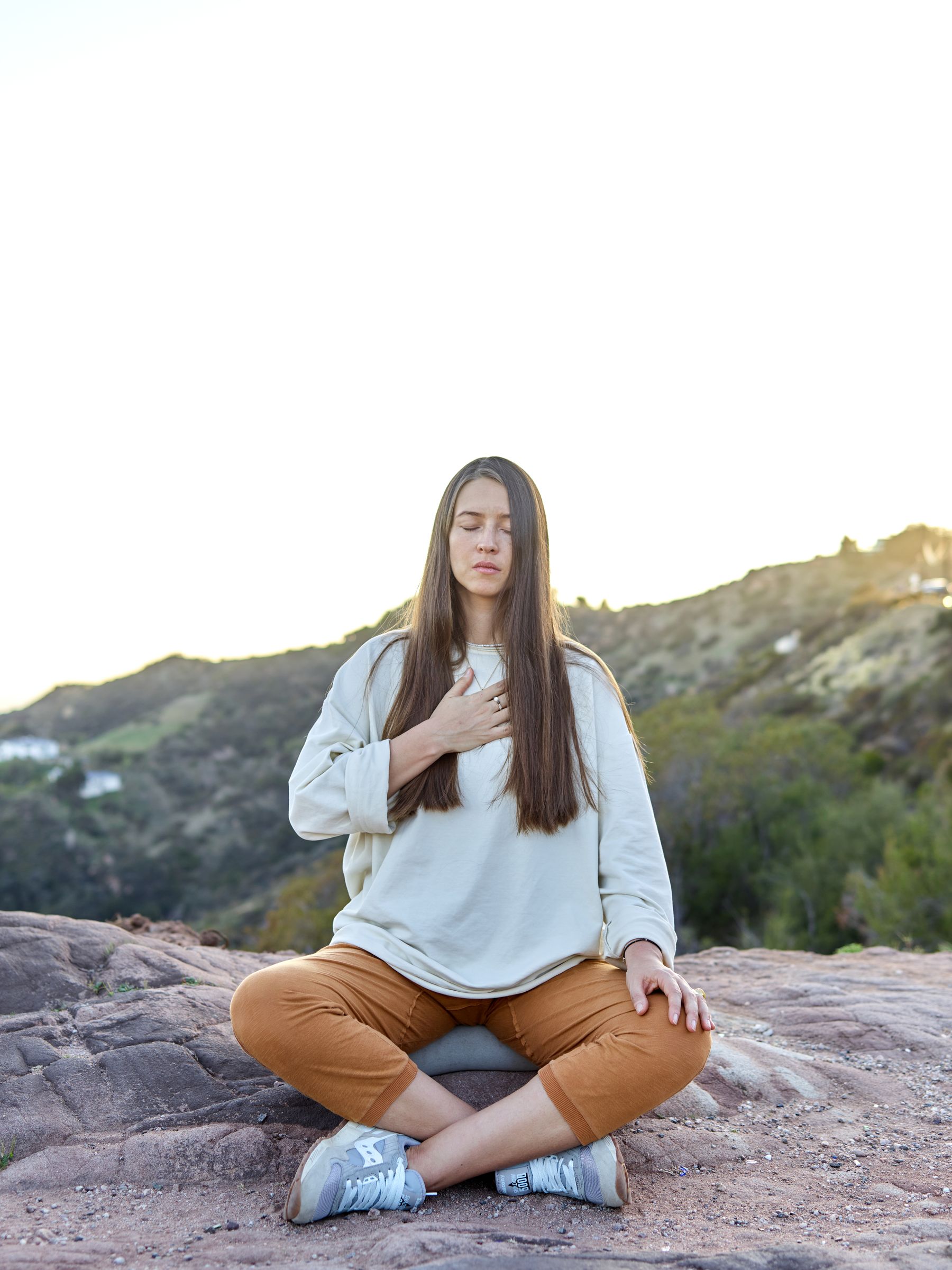 Femme assise en méditation dans un paysage montagneux