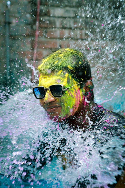 Water Splashing on a Man Wearing Sunglasses