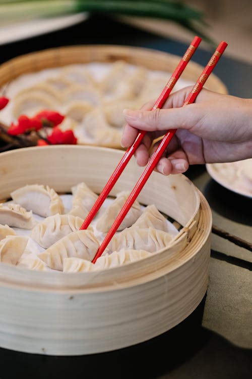 Free Anonymous person using chopsticks while taking dumpling Stock Photo