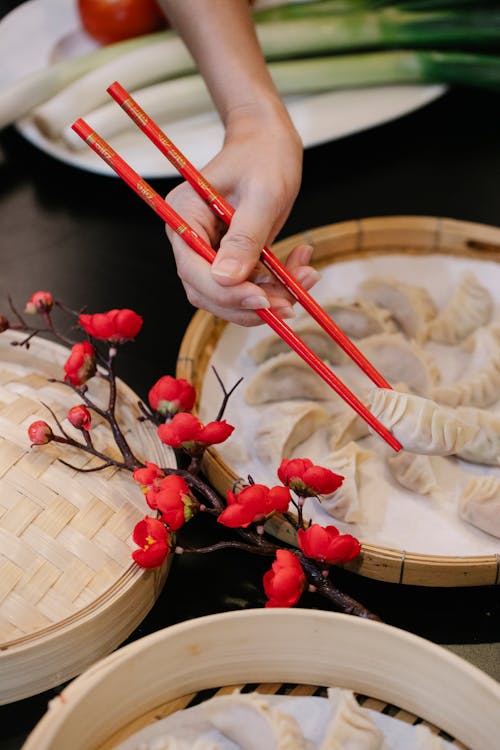 A Person Picking Up a Dumpling with Chopsticks