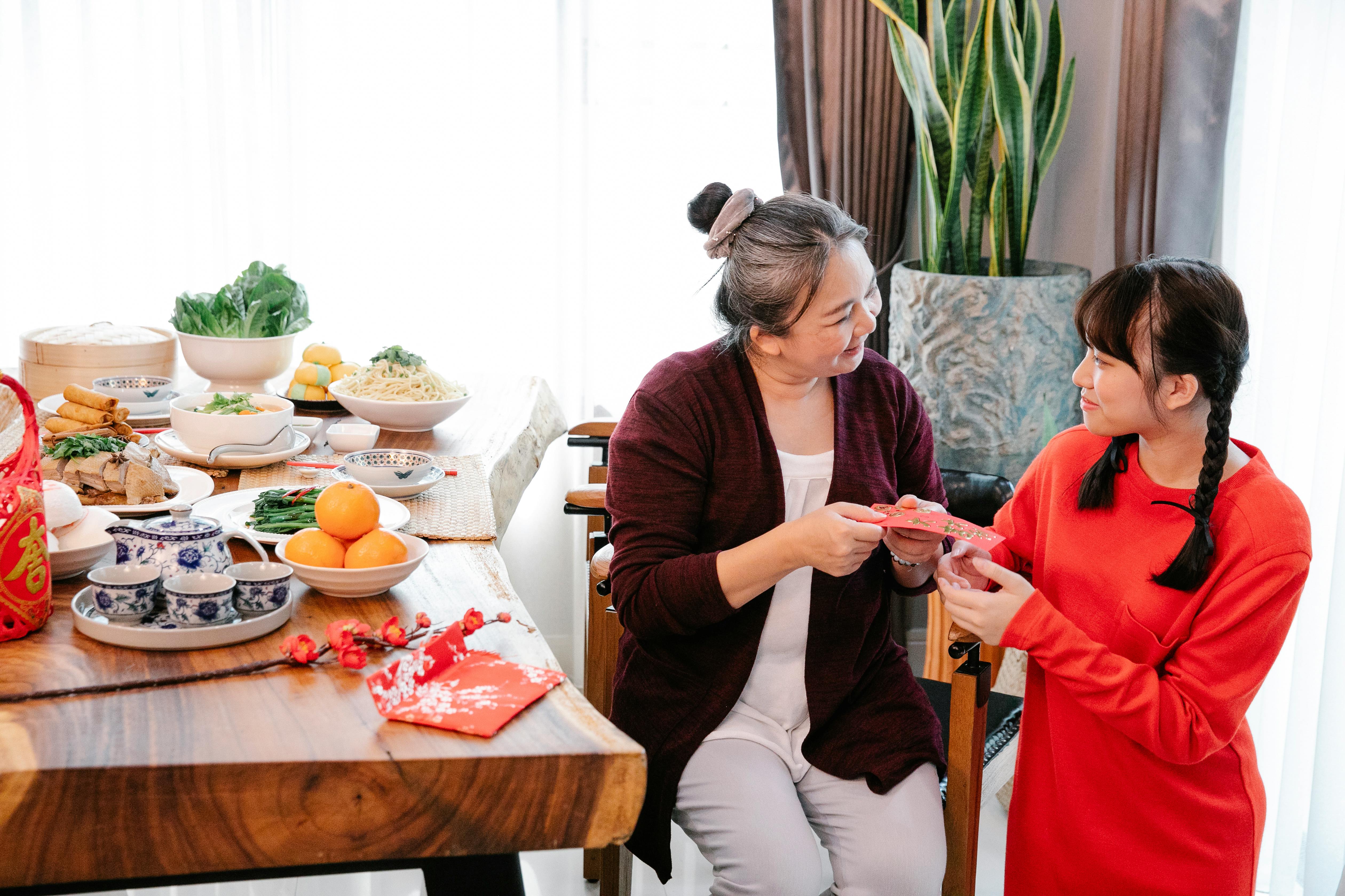 smiling asian grandma talking to granddaughter during new year holiday