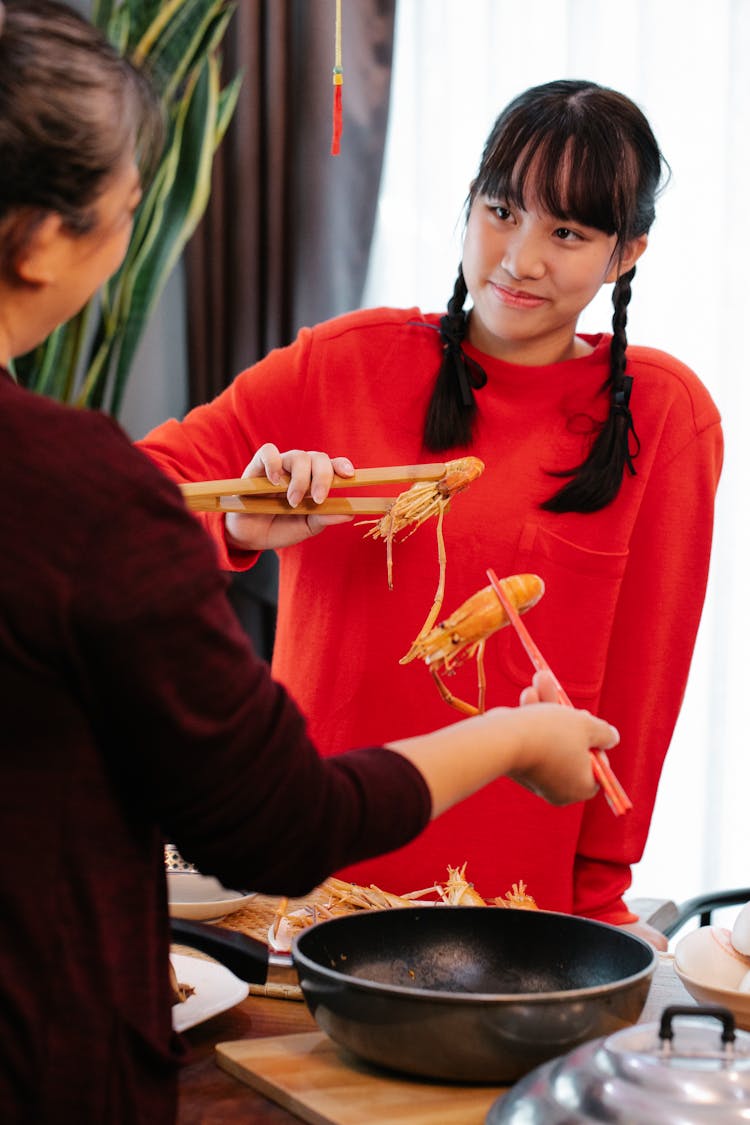 Asian Teen Talking To Crop Grandmother With Cooked Prawn