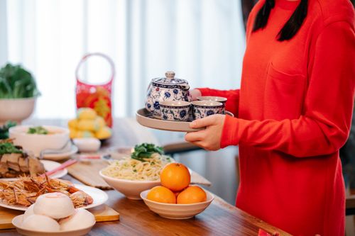 Free A vibrant spread for Chinese New Year celebration featuring traditional dishes and tea set. Stock Photo