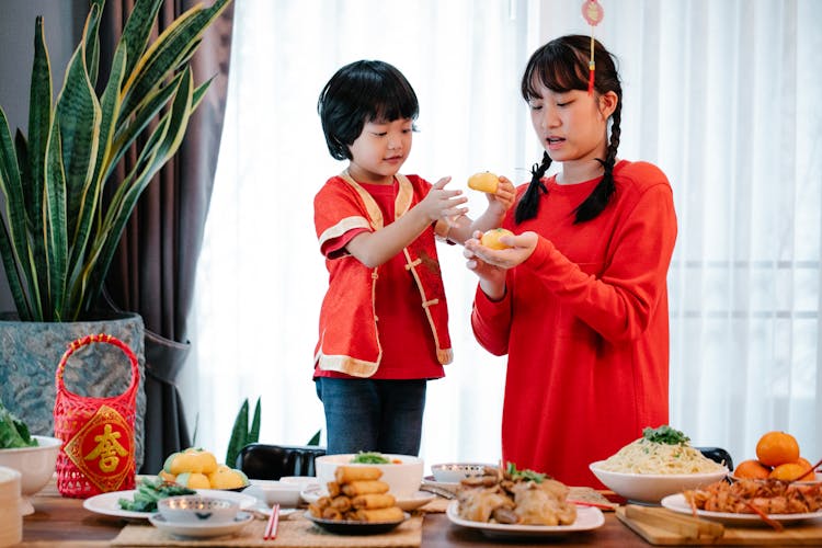 Asian Teen And Boy With Tasty Buns During Festive Occasion