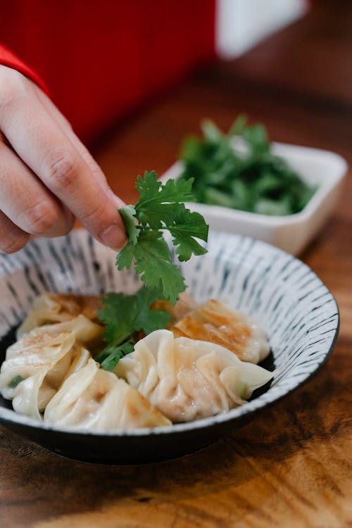 Free A Person Putting Cilantro on the Dumplings Stock Photo
