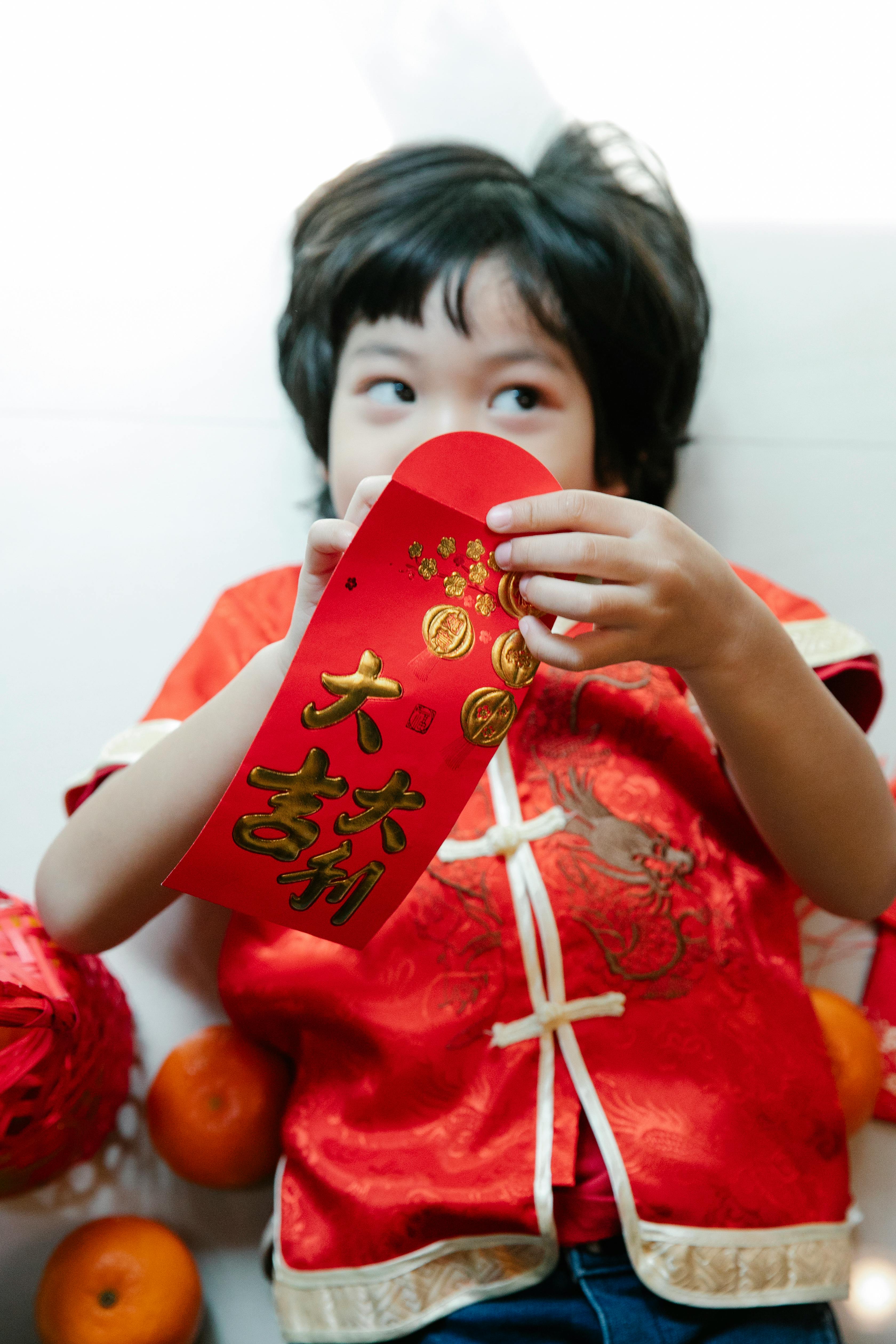 contemplative asian boy with red pocket during new year holiday