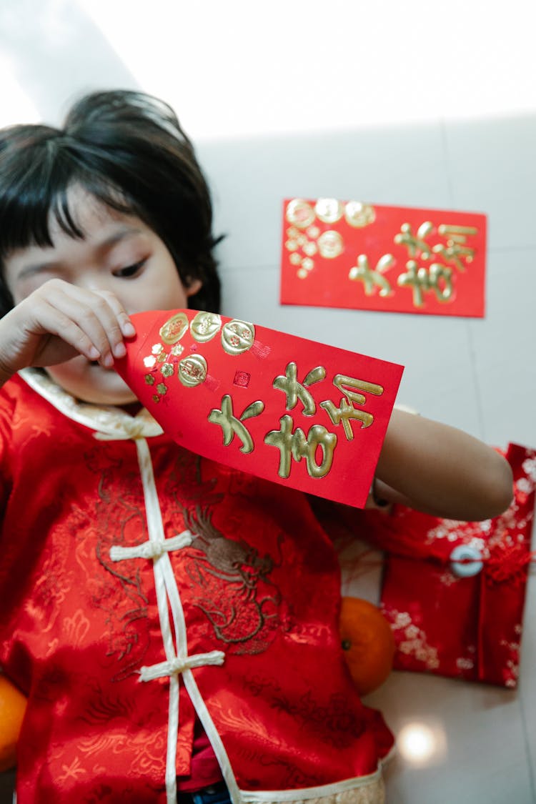 Asian Boy Opening Red Envelope During New Year Holiday