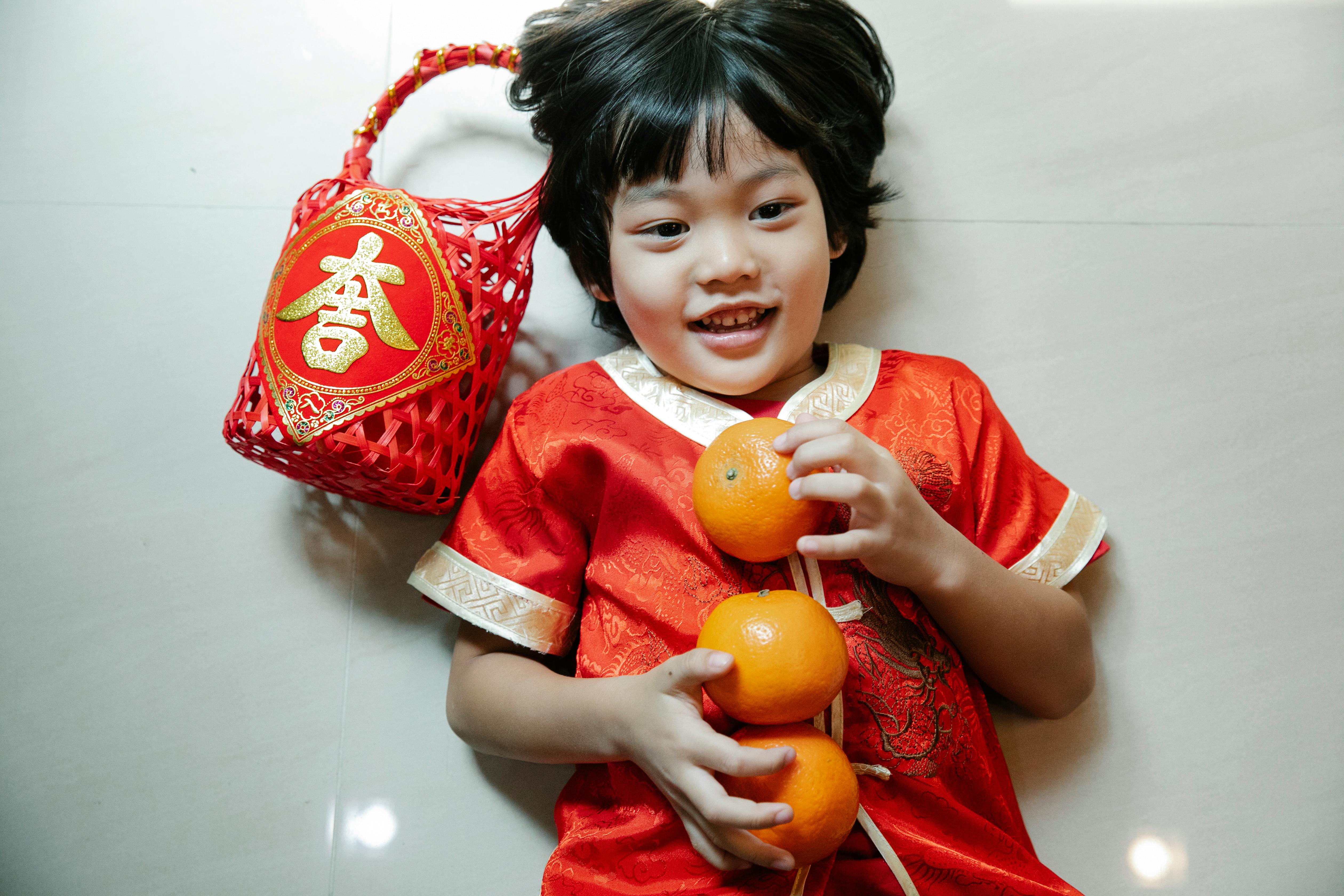 a boy with tangerines lying down on the floor