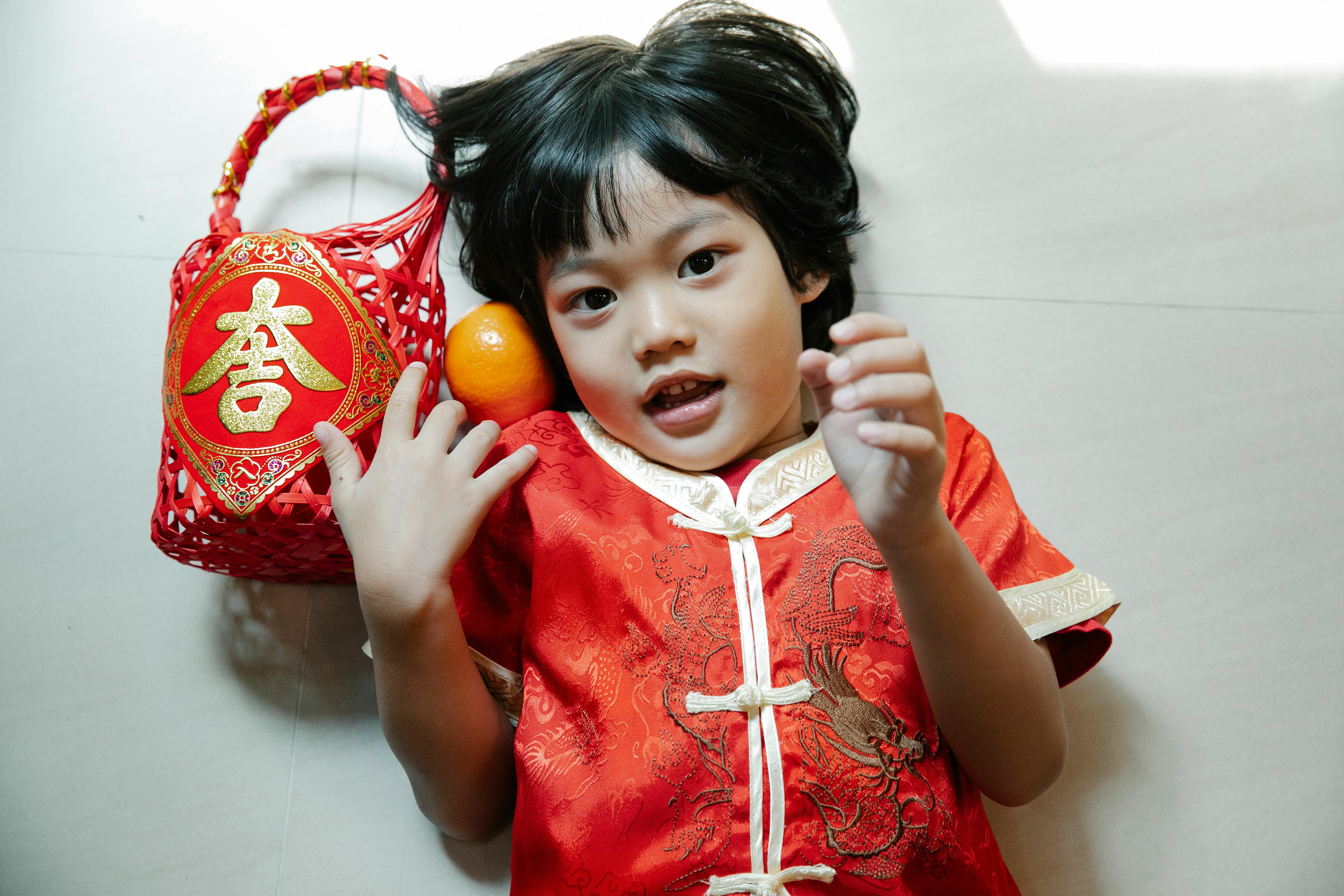 a child in red clothing lying down on the floor