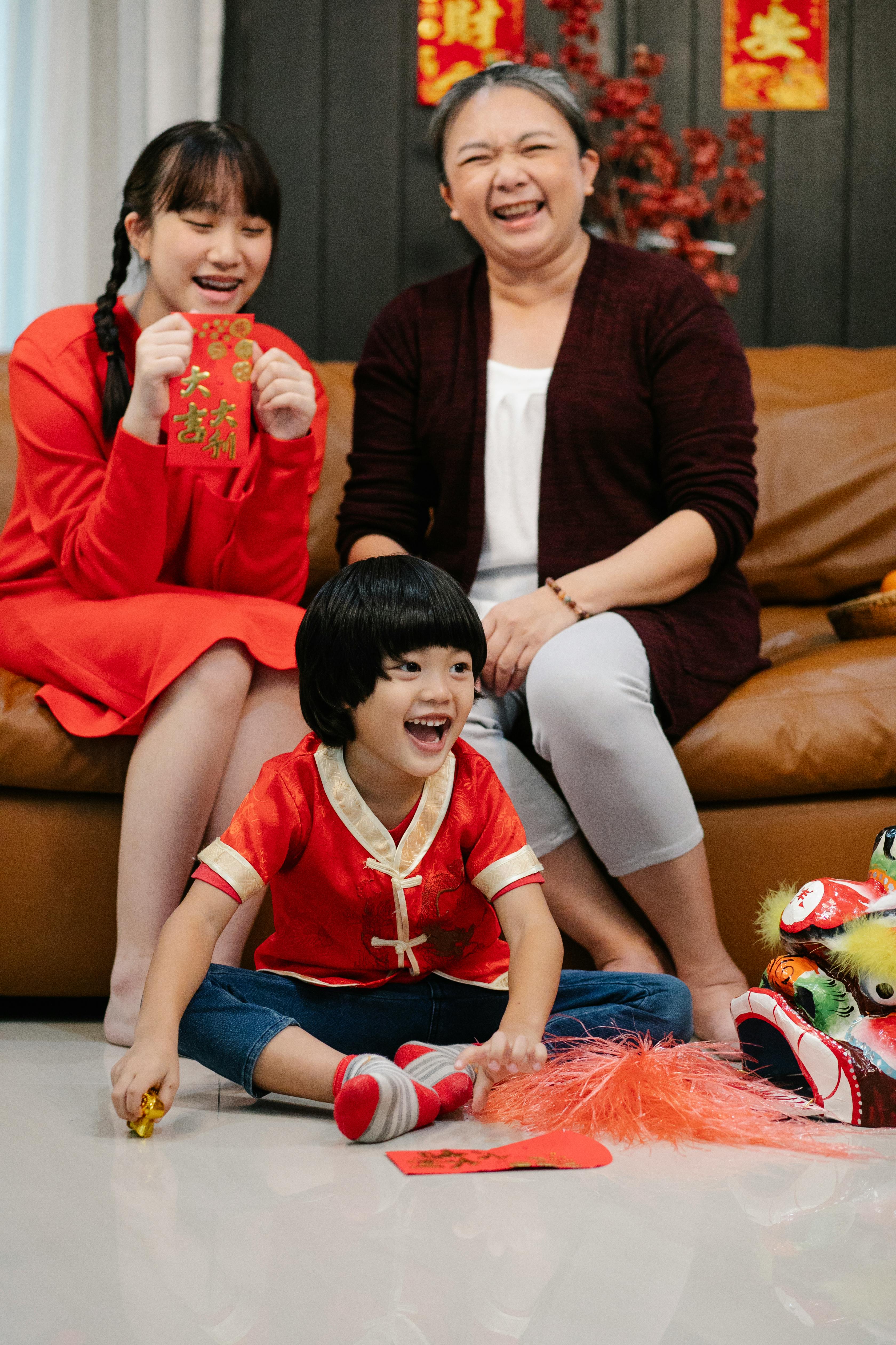 happy asian grandmother with teen and boy during festive event