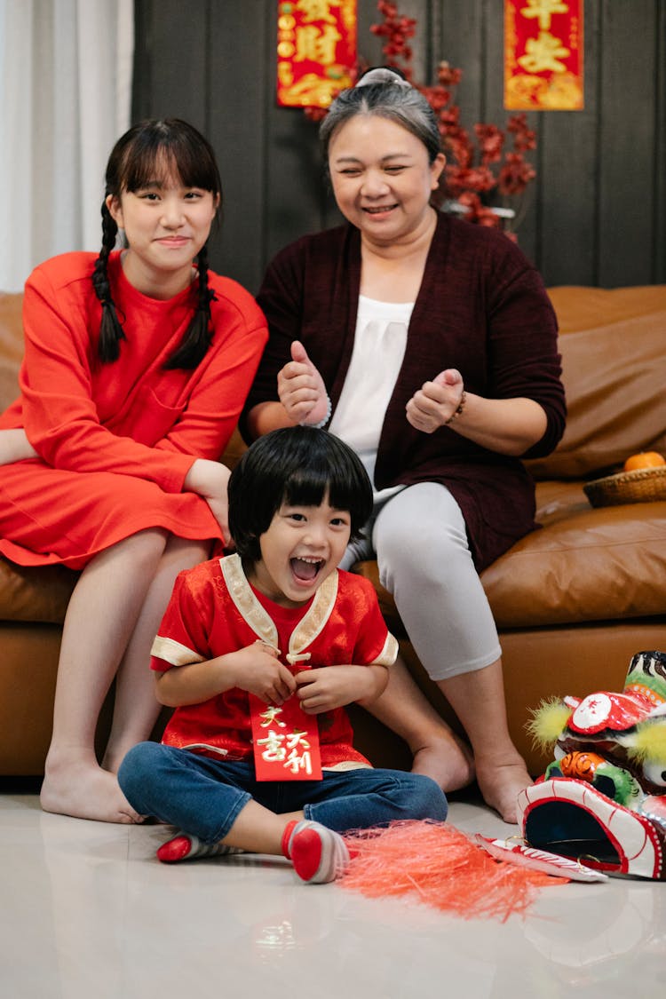 Excited Asian Boy With Sister And Grandmother During Festive Occasion