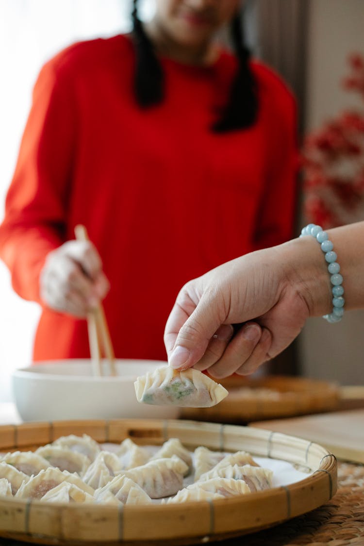 Anonymous Mother And Daughter Preparing Chinese Jiaozi Dumplings In Kitchen