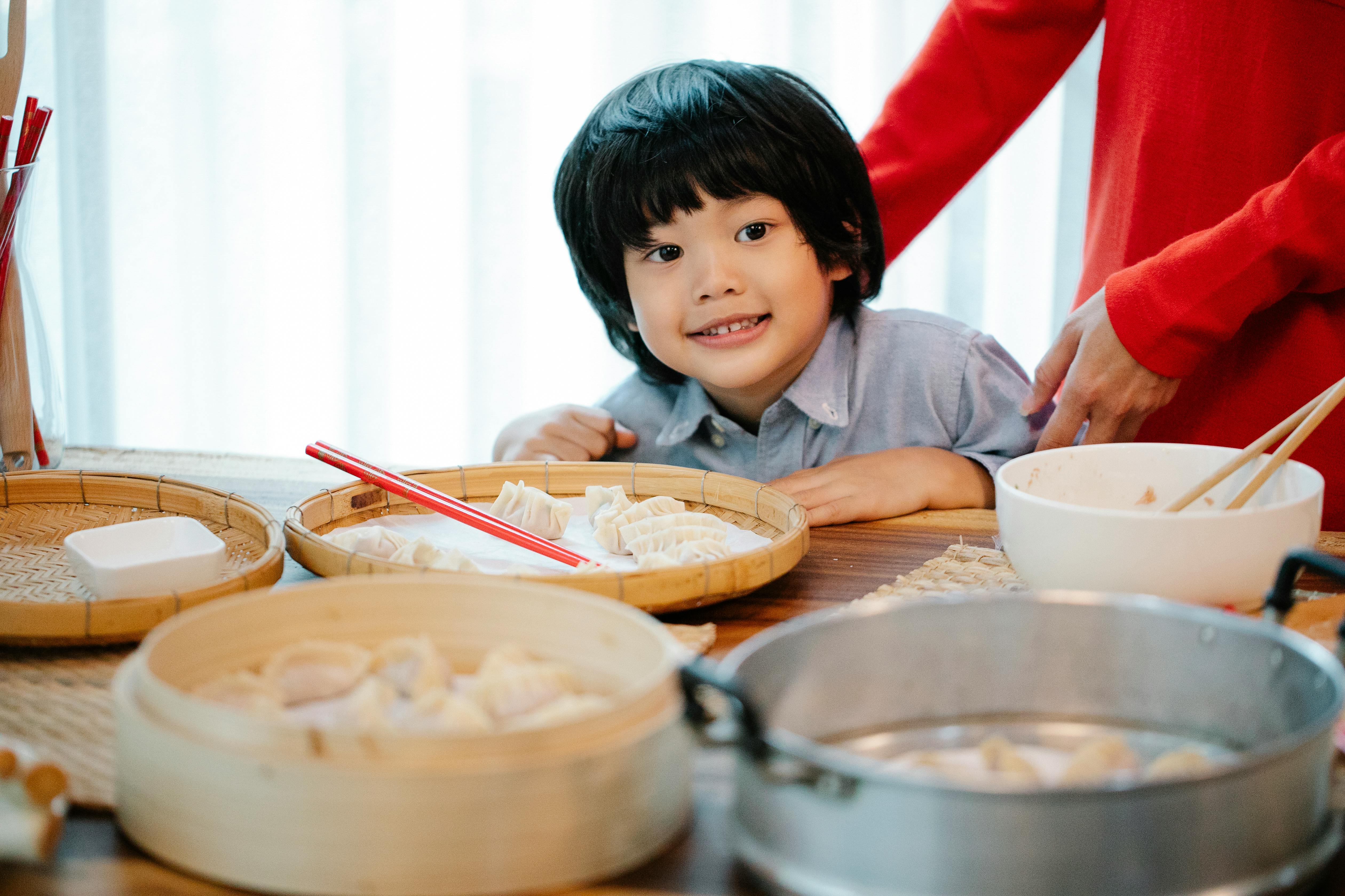 Asian Baby Eating Dumplings by Stocksy Contributor ChaoShu Li