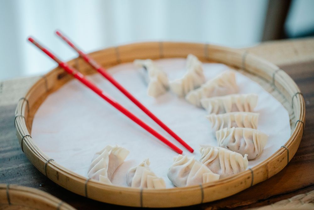Steamed dumplings in a bamboo basket with chopsticks — photo by Angela Roma on Pexels