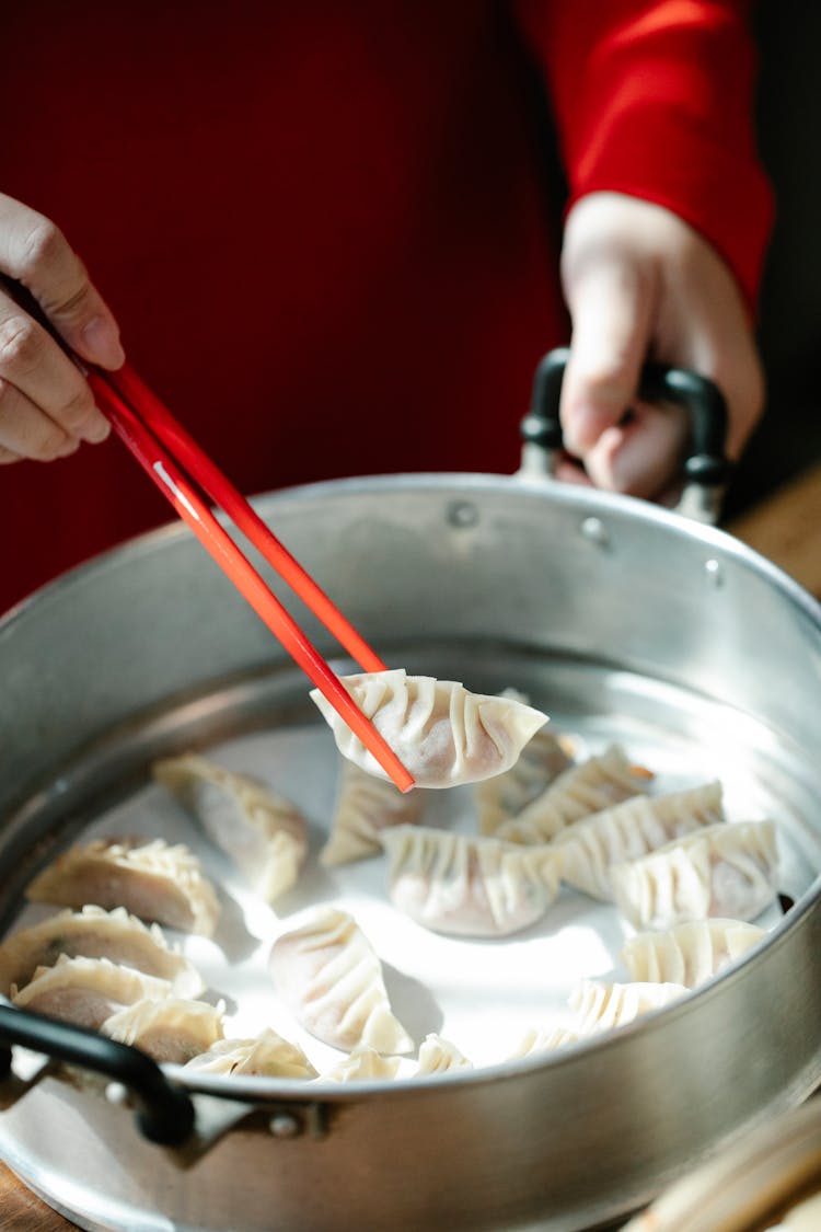 Woman Cooking Chinese Dumplings In Stainless Dishware